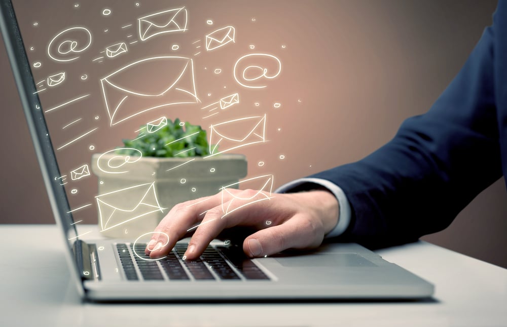 An office worker sending emails and communication with clients with the help of a portable laptop on desk concept